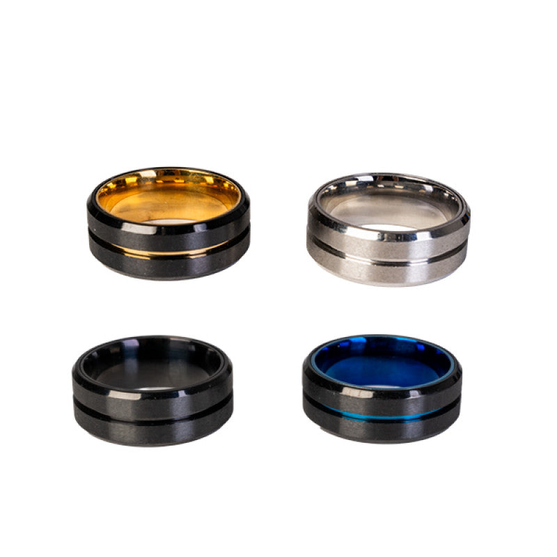 Four metallic rings in gold, silver, black, and blue on a white background